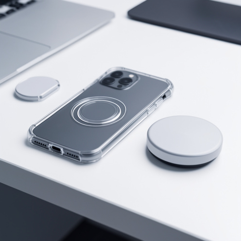 Smartphone dans une coque transparente de protection compatible avec un système de recharge magnétique, posé à côté d’un chargeur sans fil.
